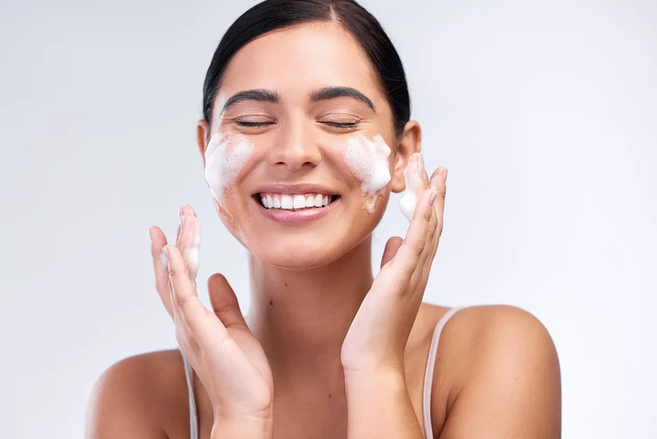 a woman washes her face